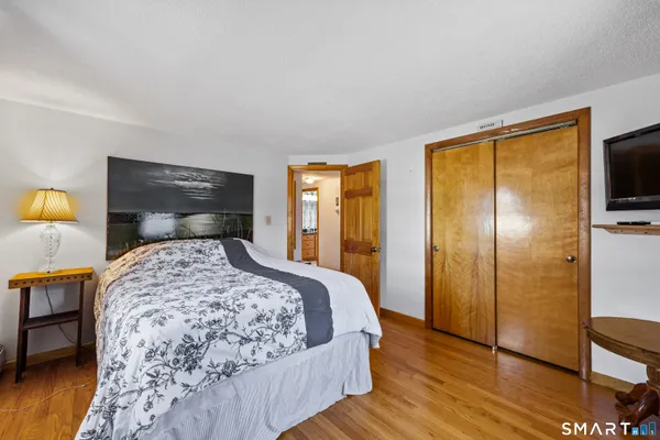 a bedroom with a bed and wooden floor