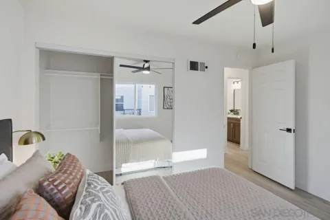 a bedroom with furniture and a glass door shower