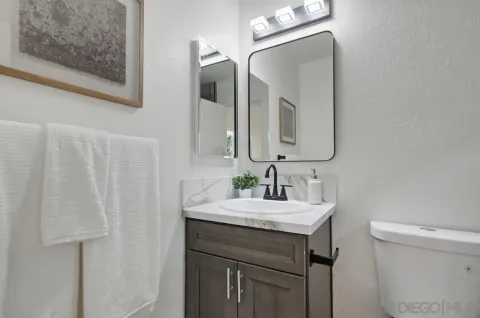 a bathroom with a sink vanity and a toilet