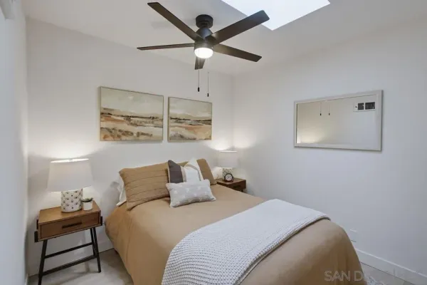 a bedroom with a bed and a lamp on the dresser