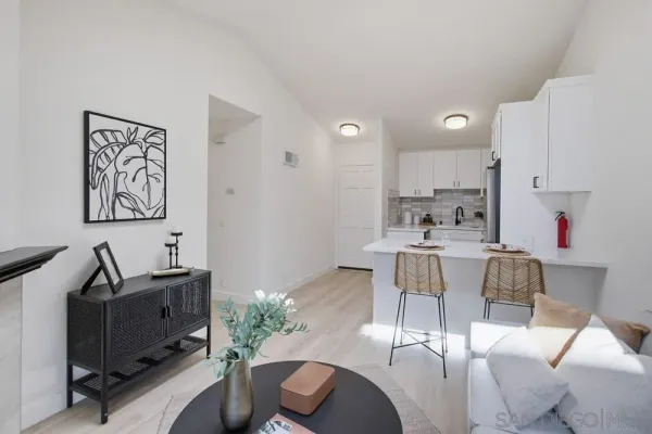 a kitchen with stainless steel appliances kitchen island granite countertop a dining table chairs and a refrigerator