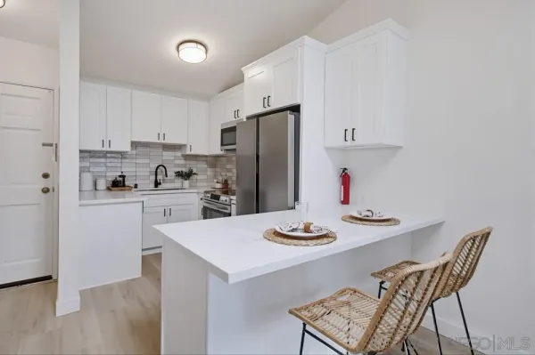 a kitchen with stainless steel appliances granite countertop a dining table and chairs