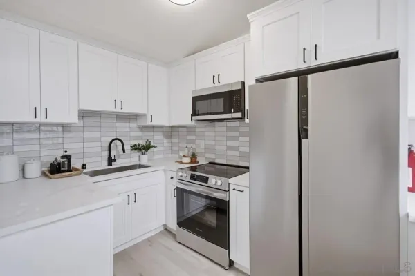 a kitchen with cabinets stainless steel appliances and sink