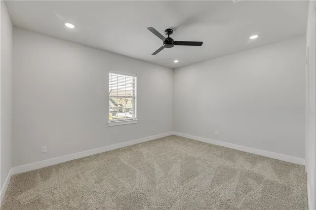 an empty room with a window and a fan