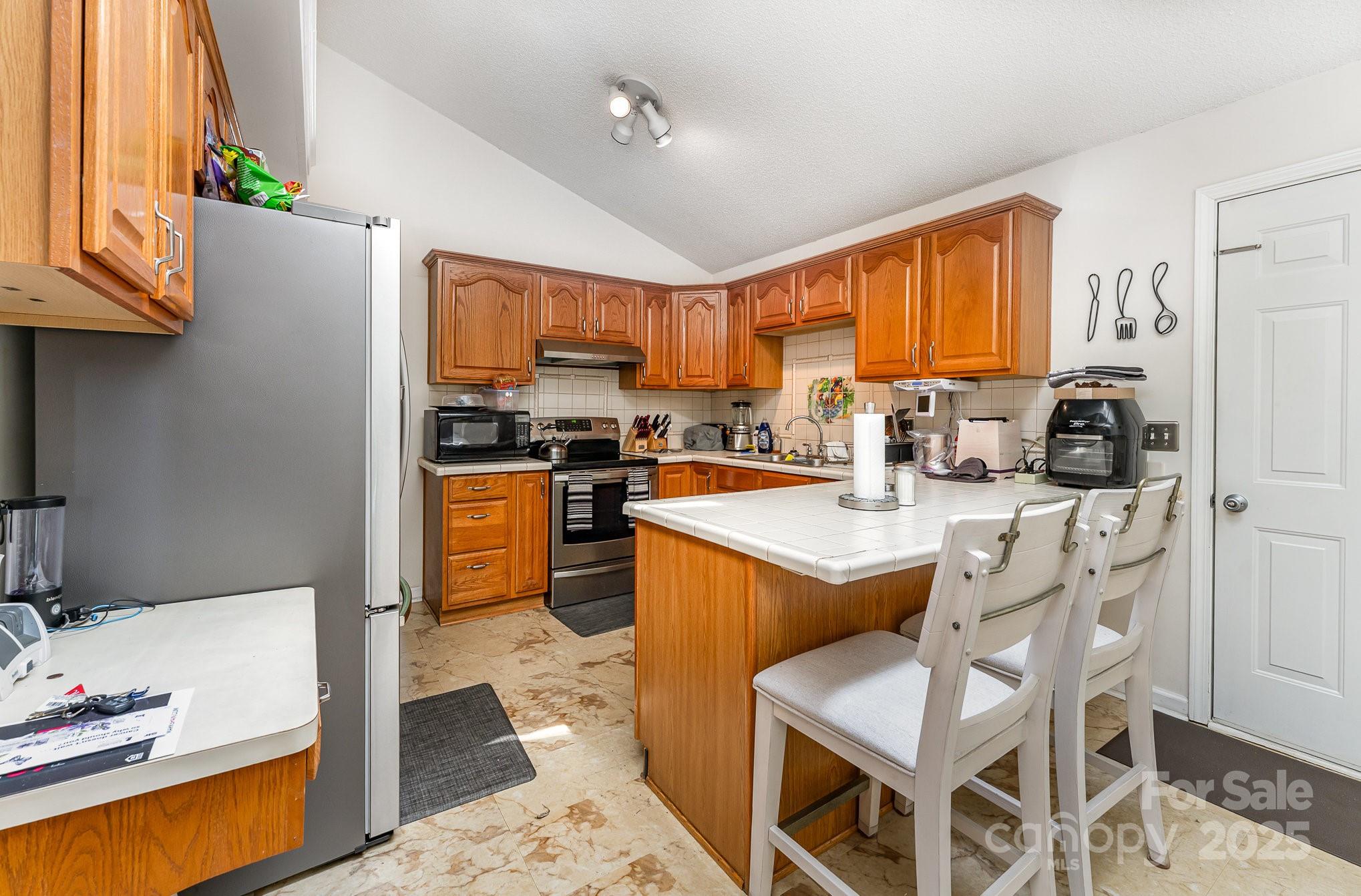 1076 Braxton Drive Concord, NC 28025 - Photo 8 of 20 a kitchen with stainless steel appliances granite countertop a stove a sink dishwasher and a refrigerator with wooden floor