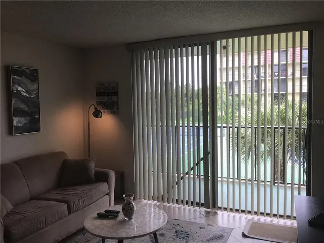 a living room with furniture and a floor to ceiling window