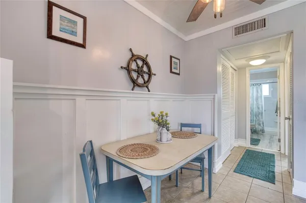 a view of a hallway that has a table and chairs in it