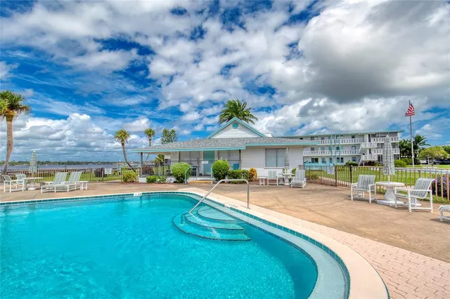 a view of a terrace with lawn chairs and a barbeque