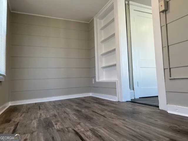 a view of a room with wooden floor and brick walls