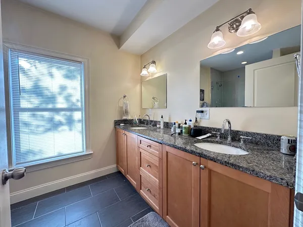 a bathroom with a granite countertop sink mirror vanity and toilet