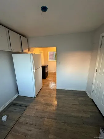 an empty room with wooden floor and entrance