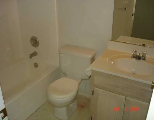 a white toilet sitting next to a bath tub