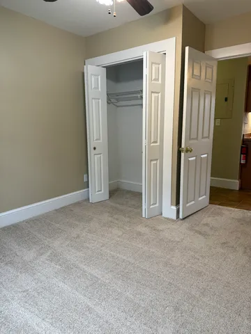 an empty room with closet and a hallway