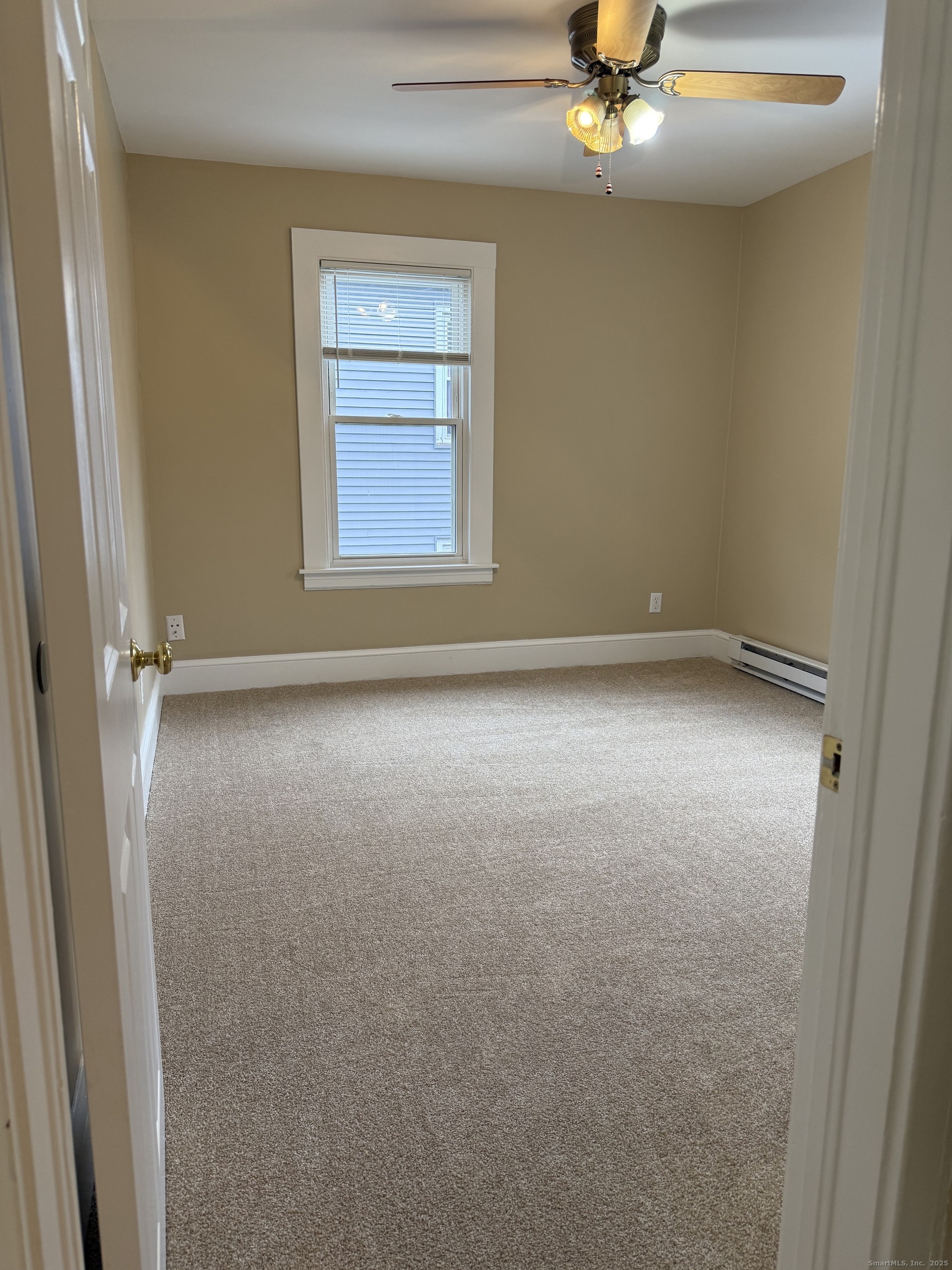 255 Main Street Plymouth, CT 06786 - Photo 10 of 14 an empty room with a chandelier fan and windows