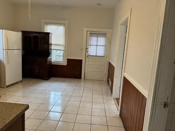 a view of a kitchen with refrigerator and furniture