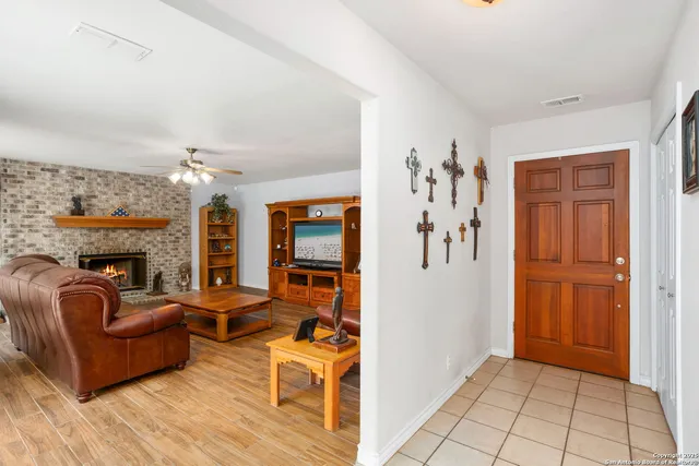 a living room with furniture a fireplace and a chandelier