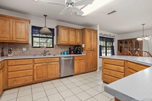 a kitchen with granite countertop a sink window and cabinets