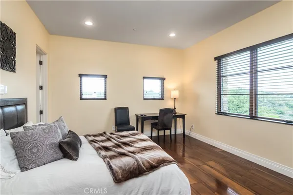 a spacious bedroom with a bed and a flat screen tv