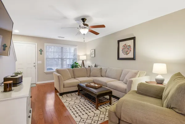 a living room with furniture a ceiling fan and a rug