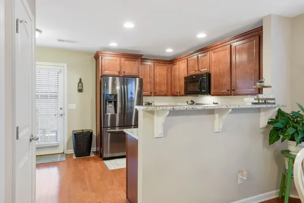 a kitchen with stainless steel appliances granite countertop a refrigerator and a stove top oven