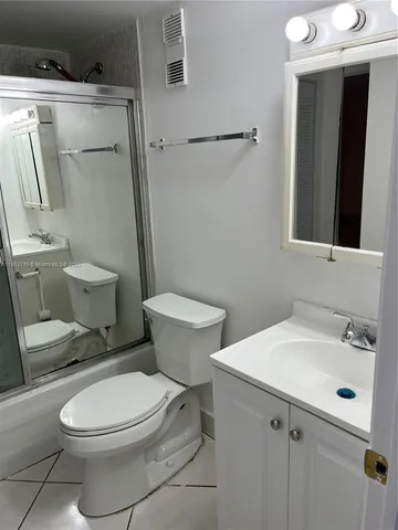 a white toilet sitting next to a bathroom sink