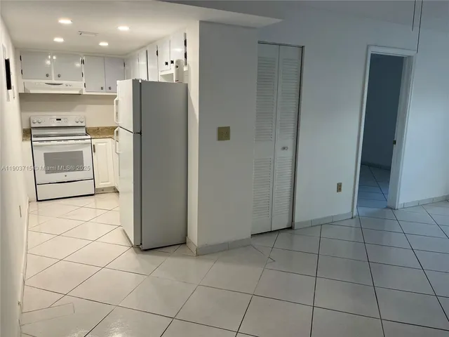 a view of kitchen with stainless steel appliances granite countertop a refrigerator and a stove top oven