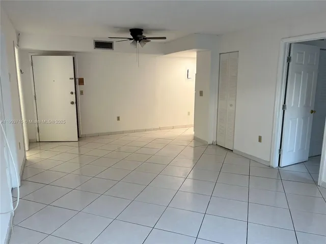 an empty room with fan and entrance