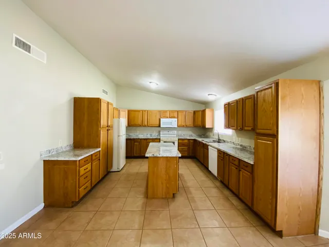 a view of an empty room with a kitchen