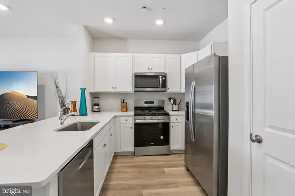 a kitchen with kitchen island a refrigerator sink and stove