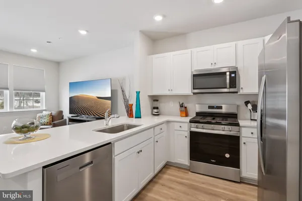 a kitchen with stainless steel appliances a stove sink microwave and cabinets