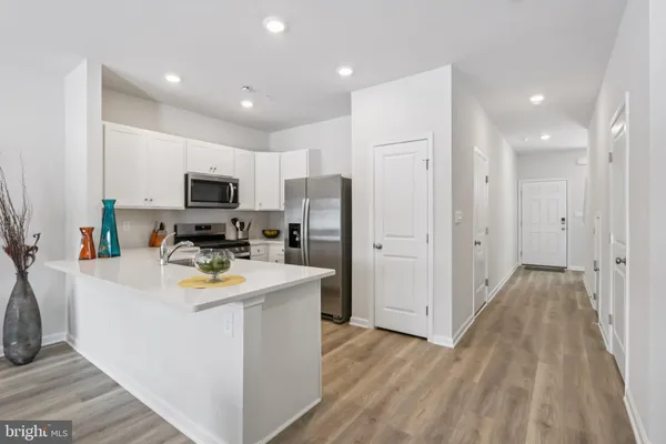 a view of a kitchen with wooden floor and electronic appliances