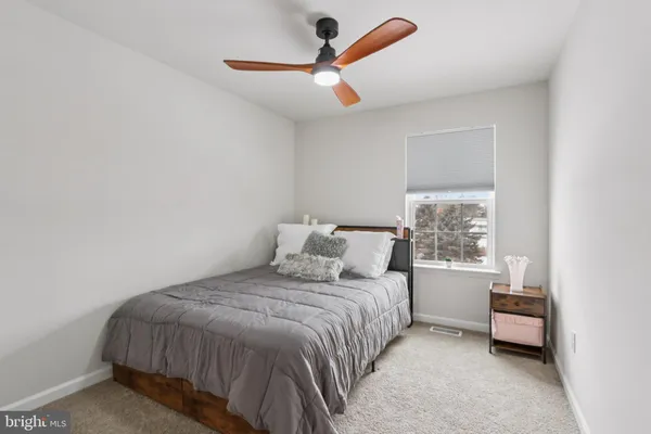 a bedroom with a bed and a ceiling fan