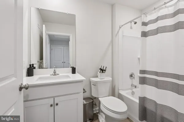 a bathroom with a sink a toilet a mirror and shower curtain