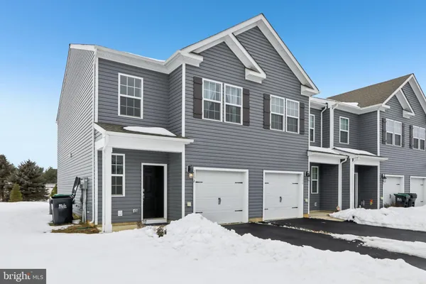 a front view of a house with yard and parking