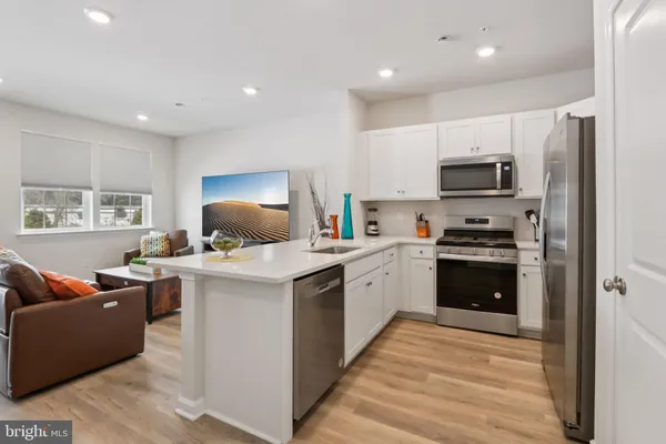 a kitchen with kitchen island a stove a sink and a refrigerator