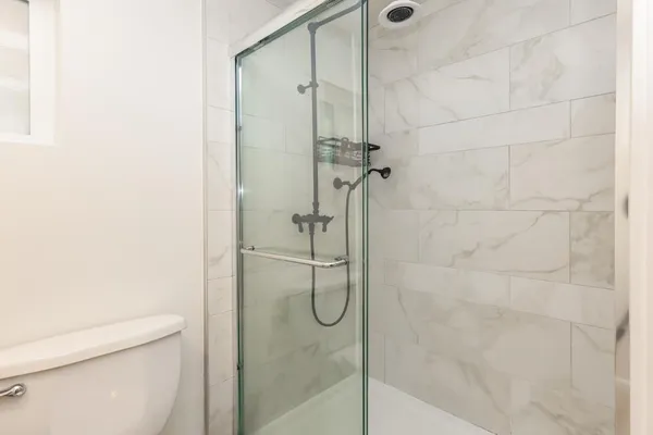 a bathroom with a granite countertop sink toilet and shower