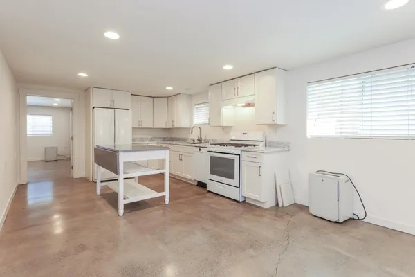 a kitchen with cabinets appliances a sink and a counter top space