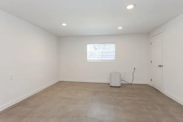 an empty room with a window and a bathroom