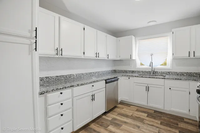 a kitchen with granite countertop granite countertop white cabinets and sink