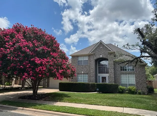 a front view of a house with a garden