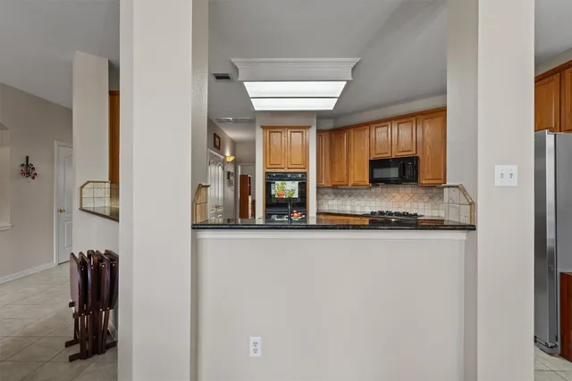 a kitchen with stainless steel appliances granite countertop a refrigerator and a stove