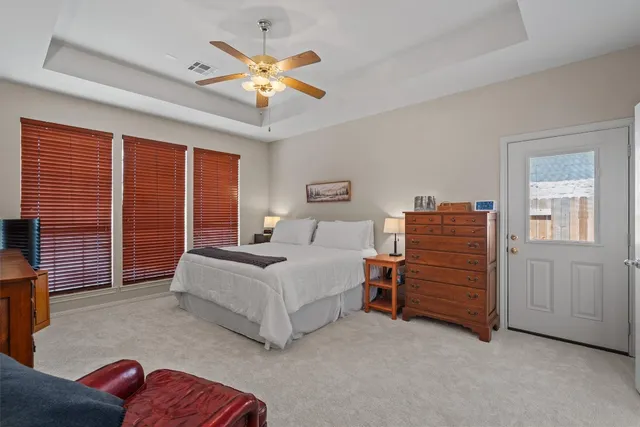 a spacious bedroom with a bed and a chandelier