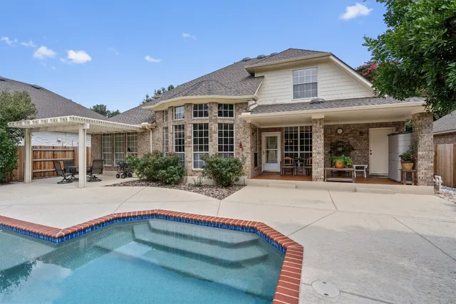 an aerial view of a house with yard and swimming pool