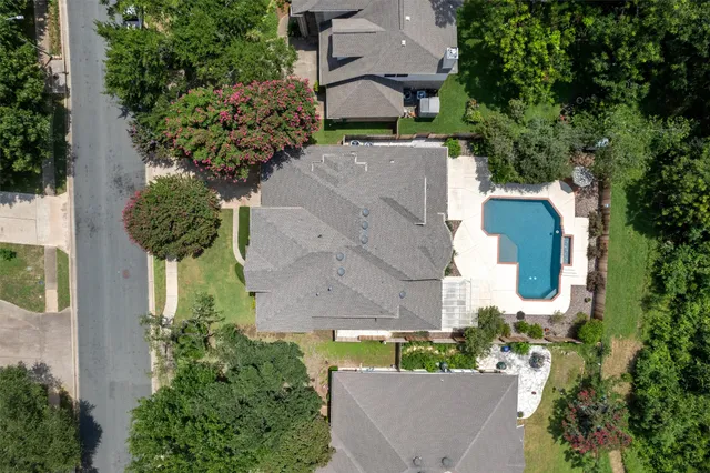 an aerial view of a house with yard and swimming pool