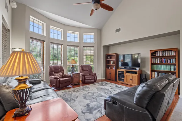 a living room with furniture a flat screen tv and a floor to ceiling window