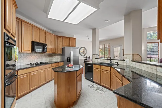 a kitchen with stainless steel appliances granite countertop a sink stove and microwave