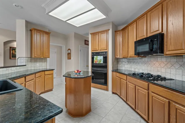 a kitchen with stainless steel appliances granite countertop a stove a sink dishwasher a microwave oven and a refrigerator