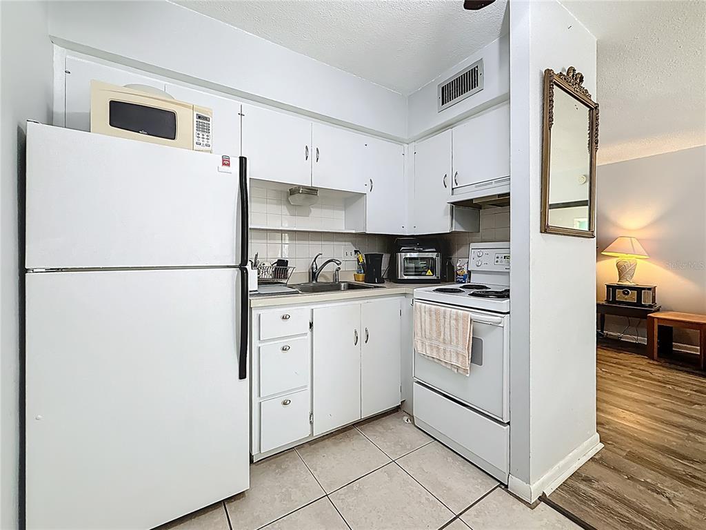 250 Rosery Road Northwest, Unit 228 Largo, FL 33770 - Photo 13 of 27 a kitchen with stainless steel appliances a refrigerator sink and cabinets