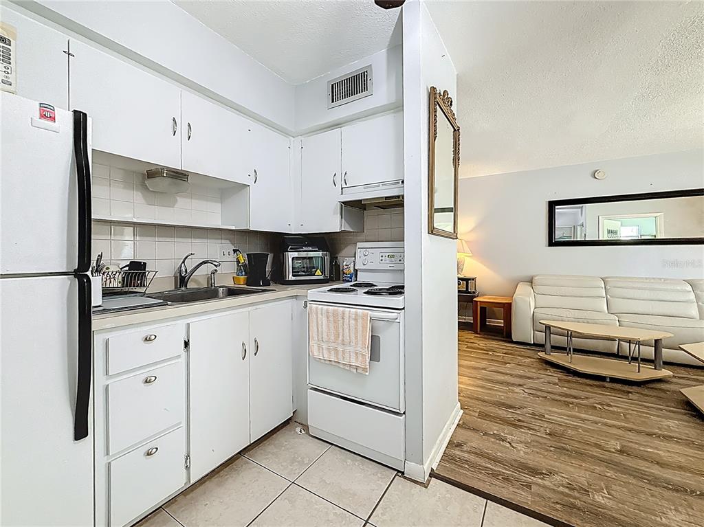 250 Rosery Road Northwest, Unit 228 Largo, FL 33770 - Photo 14 of 27 a kitchen with granite countertop white cabinets and white appliances