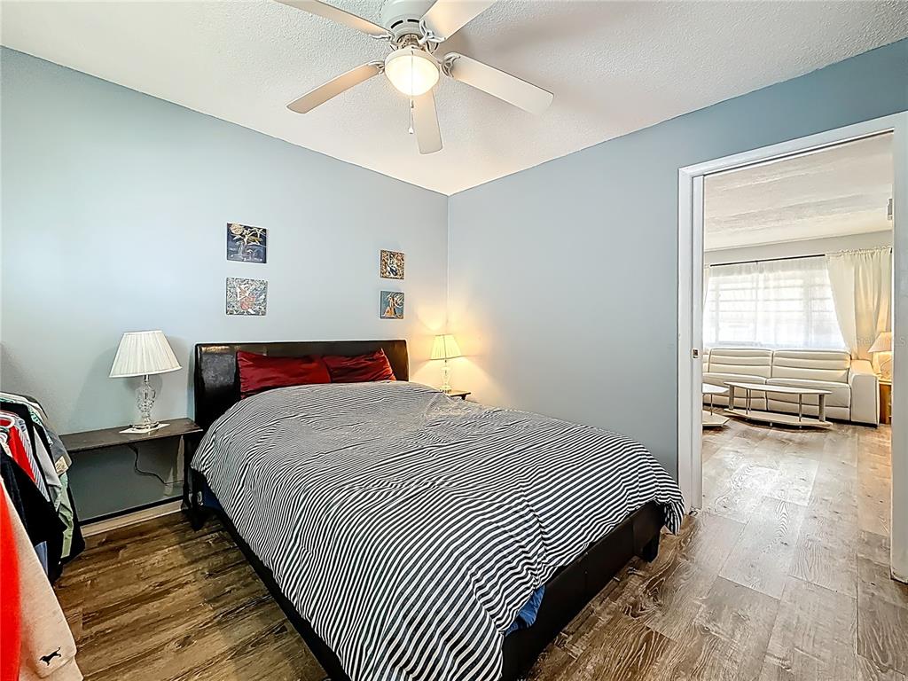 250 Rosery Road Northwest, Unit 228 Largo, FL 33770 - Photo 15 of 27 a bedroom with a bed and a chandelier